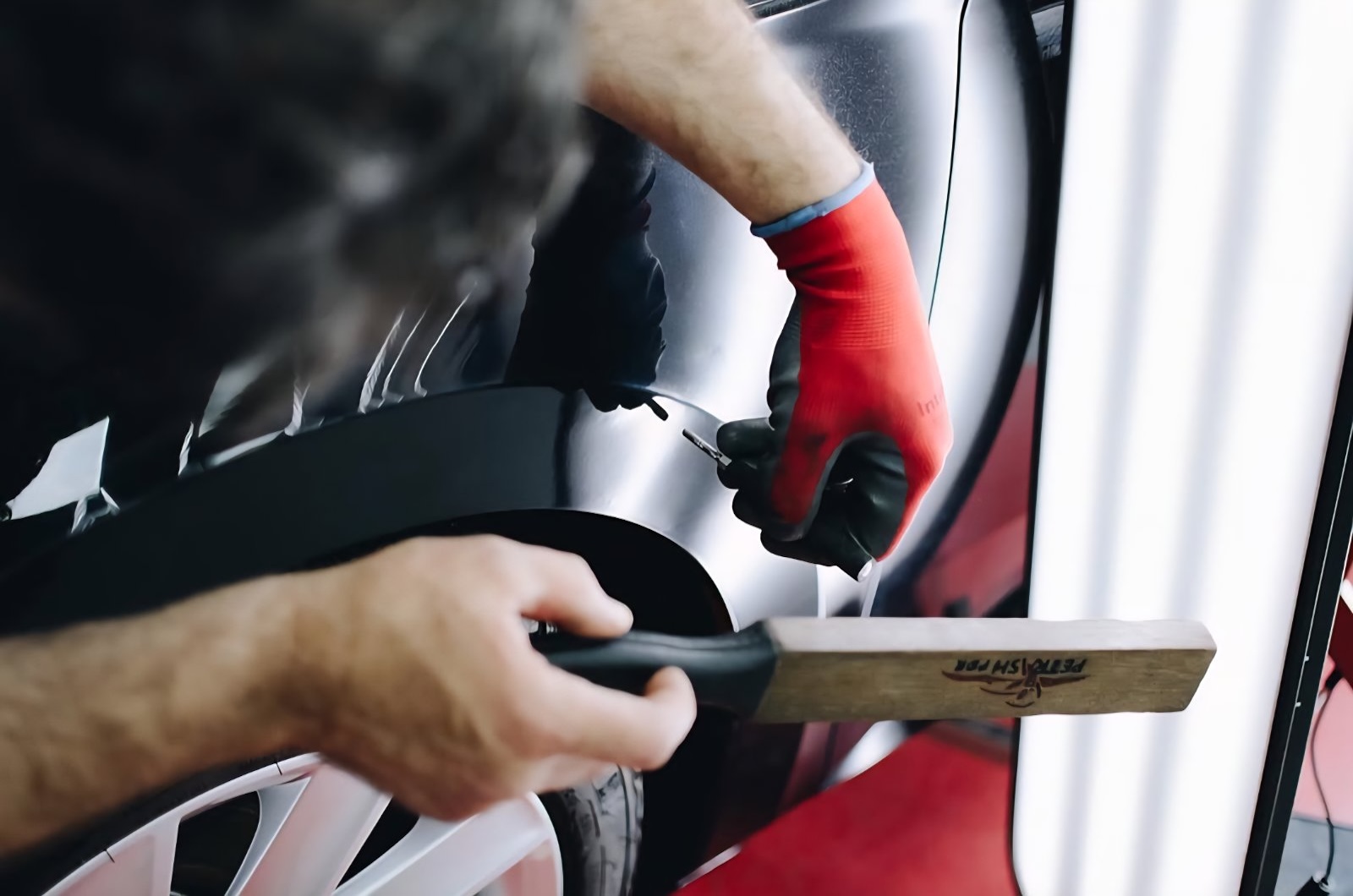 Technician performing paintless dent repair